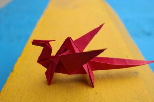 red origami dragon on yellow and blue floor