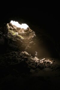 This is a picture of a person in a cave with light coming down.