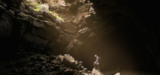 This is a picture of a person in a cave with light coming down.