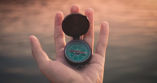 this is a picture of a compass and a hand holding it