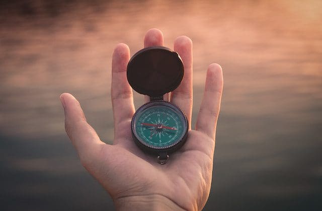 this is a picture of a compass and a hand holding it