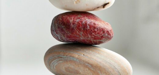This is a picture of four stones of different colors balancing on one another.
