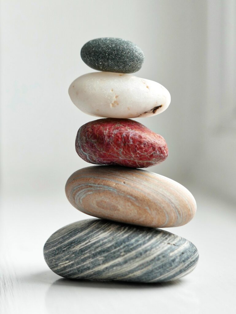 This is a picture of four stones of different colors balancing on one another. 