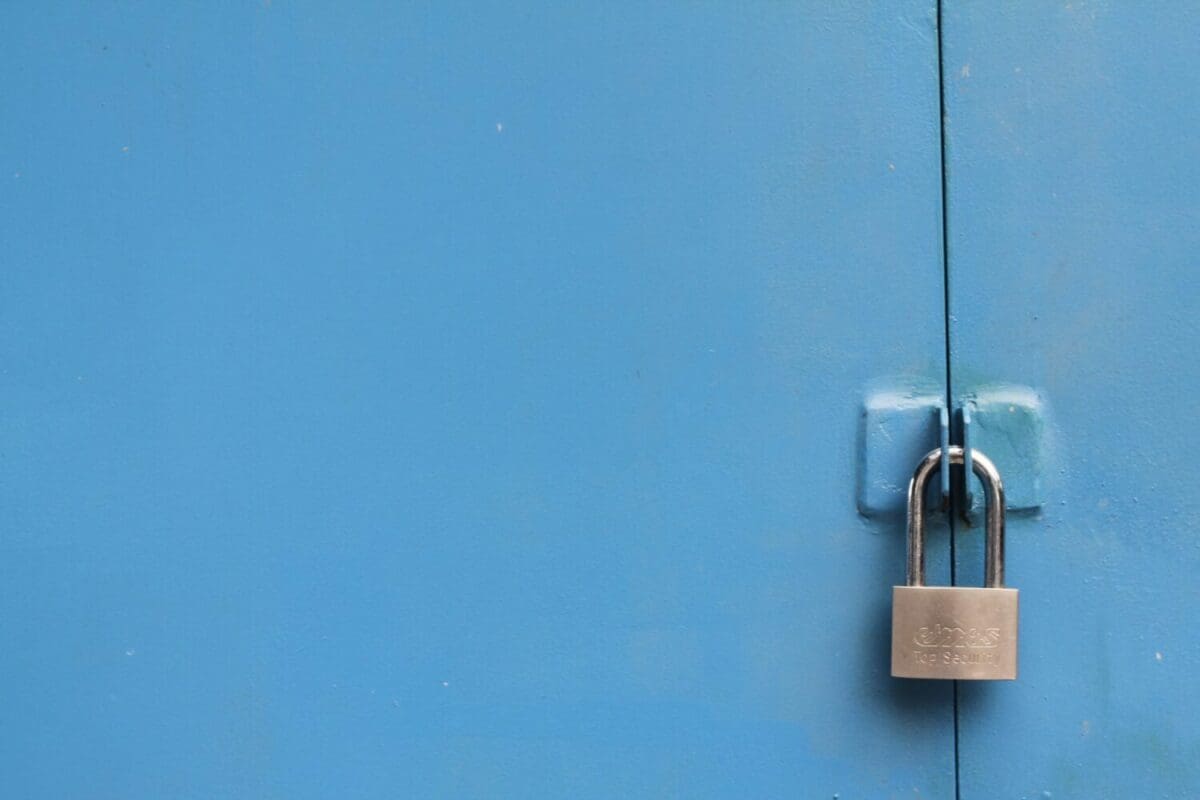 This is a photo of a padlock that is locked and its locked a blue door.